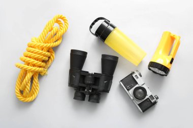 Dürbün, halat, seyahat şişesi, kamera ve meşale beyaz arka planda