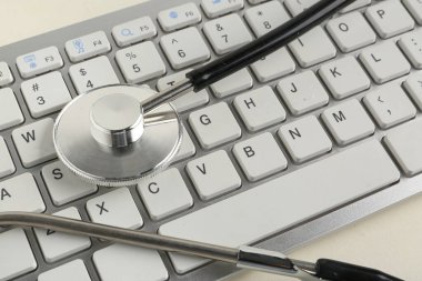Modern klavye ve steteskop, yakın plan.