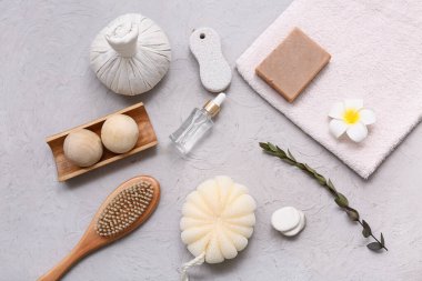 Bitkisel poşetli spa kompozisyonu, banyo süngeri, masaj vücut fırçası, ahşap masaj topları, grunge arka planında bir şişe gerekli yağ ve sabun.