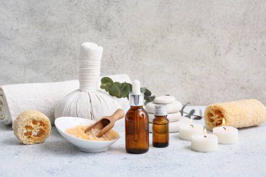 Lifli güzel kompozisyon, bitkisel çanta, deniz tuzu, gerekli yağ şişesi ve grunge arkaplanda mumlar.