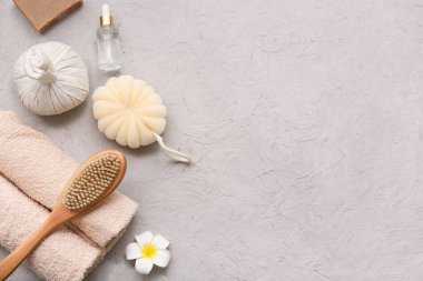 Banyo malzemeleri, bitkisel poşet, tesisat çiçeği ve grunge arkaplanda gerekli yağı içeren bir kompozisyon.