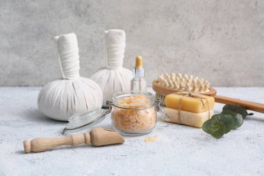 Cam kavanoz deniz tuzu, kepçe, bitkisel torbalar ve grunge arkaplanda sabun kalıpları ile kompozisyon