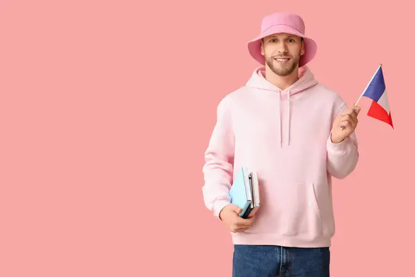 stock image Male French student with books and flag on pink background