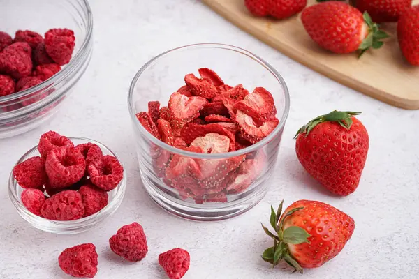 Stock image Bowls with tasty freeze-dried and fresh berries on light background