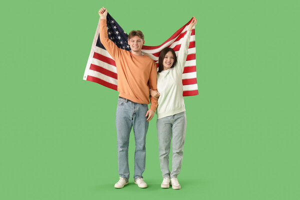 Young couple with flag of USA on green background