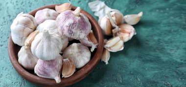 Yeşil desenli arkaplanda taze sarımsak tabağı.