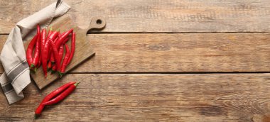 Ahşap zemin üzerinde acı kırmızı biberli kompozisyon, metin için boşluk, üst görünüm