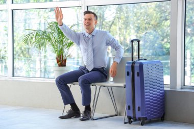 Havaalanı koridorunda el sallayan yakışıklı hostes.