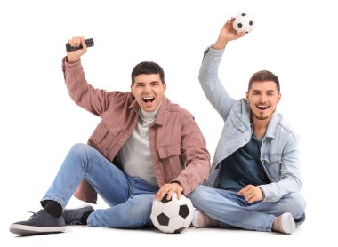 Beyaz arka planda futbol izleyen yakışıklı genç kardeşler.