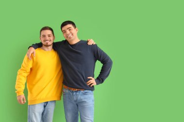 Yeşil arka planda yakışıklı genç kardeşler