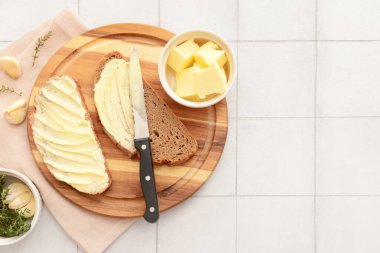 Tahta tahta tahta, ekmek dilimleri, sarımsak ve bir kase taze tereyağı.