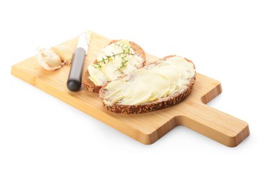 Tahta tahta ekmek dilimleri, taze tereyağı ve beyaz arka planda sarımsak.