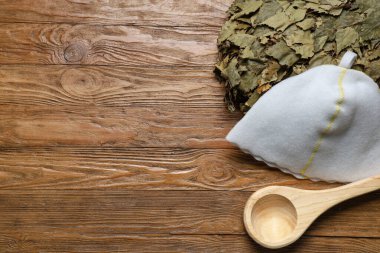Ahşap arka planda sauna için kepçe, kepçe ve huş süpürgesi