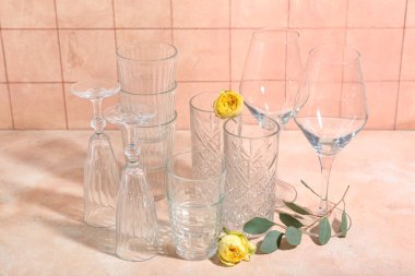 Turuncu fayans duvarının yanındaki masada gözlük ve güller