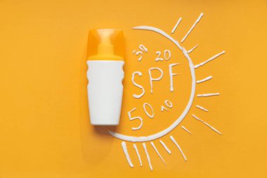 Güneş kremi şişesiyle kompozisyon, kelime SPF ve renk arkaplanındaki kremden yapılmış numaralar