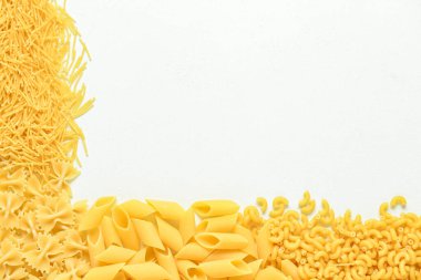 Beyaz arka planda farklı ham makarnayla kompozisyon