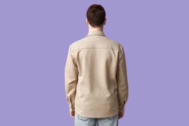 Leylak arka planda bej yakalı, şık bir genç adam.