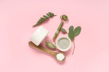 Yüz masajı silindiri ve pembe arka planda kozmetik maske için doğal malzemeler