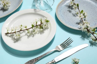 Mavi arka planda çiçek açan dalları olan güzel masa ayarları