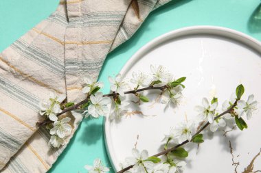 Turkuaz arka planda çiçek açan dalları olan güzel masa ayarları