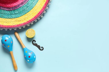 Meksika sombrerosu, marakas, limon ve mavi arka planda kağıt bıyıklı. Cinco de Mayo