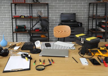 Servis merkezindeki masa üzerinde tamir araçları olan teknikler