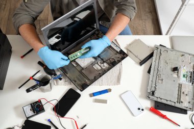 Servis merkezinde dizüstü bilgisayarı tamir eden erkek teknisyen.
