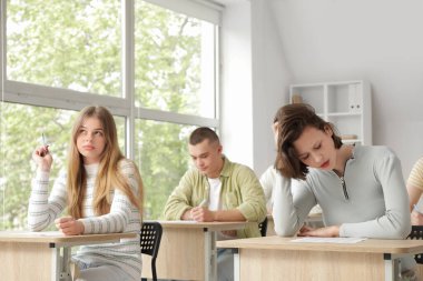 Öğrenciler sınıftaki sıralarda sınavı geçiyor