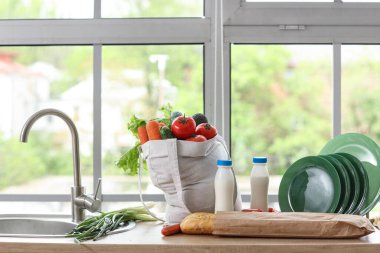 Mutfak lavabosunun yanında bir alışveriş çantası.