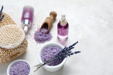 Açık arkaplanda lavanta yağı, banyo süngeri ve deniz tuzu içeren güzel bir kompozisyon, yakın plan.