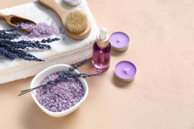 Mumlar, lavanta yağı ve bej arka planda deniz tuzu içeren güzel bir kompozisyon. Yakın plan.