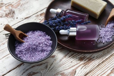 Ahşap zemin üzerinde deniz tuzu ve şişe lavanta yağıyla güzel bir kompozisyon, yakın plan.