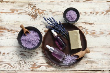 Ahşap zemin üzerinde deniz tuzu ve şişe lavanta yağıyla güzel bir kompozisyon.