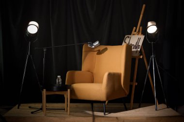 Koltuklu, mikrofonlu ve ışıklı stand-up sahnesinin görüntüsü