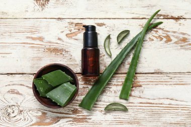 Ahşap kase ve ahşap arka planda gerekli aloe vera yağı.