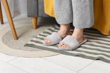 Odada rahat terlikler içinde kadın bacakları, yakın plan.