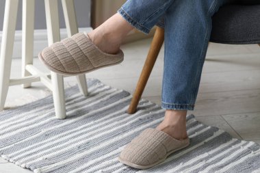 Kadın bacakları şık terliklerle odada, yakın plan.