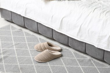 Yatak odasının yanında yerde yumuşak terlikler.