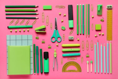 Pembe arka planda farklı okul kırtasiyesi. Üst görünüm