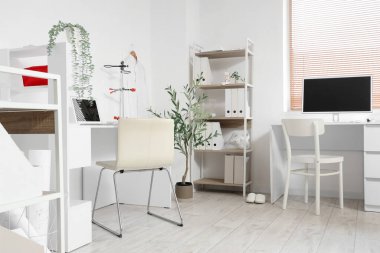 Masaları ve raf ünitesi olan bir tıp bürosu.