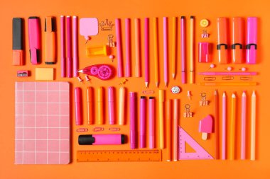 Okul malzemeleri turuncu arka planda. Üst görünüm