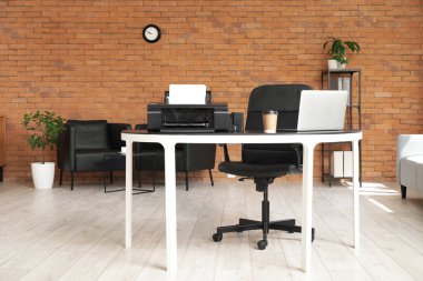 Ofis içinde dizüstü bilgisayarı ve kahve fincanı olan modern yazıcı.