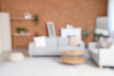 Gri koltukları, şöminesi ve kahve masası olan bulanık oturma odası manzarası.