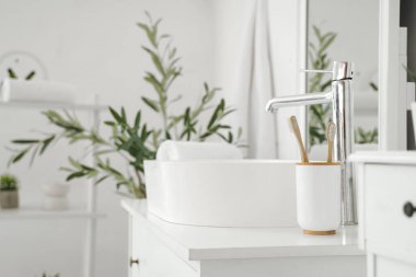 Klozet ve dekoratif zeytin ağacı olan modern banyo.