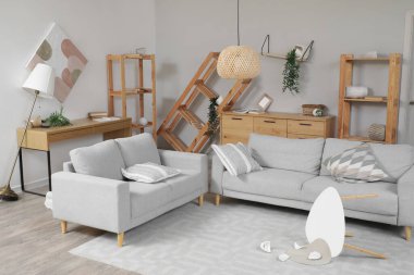 Depremden sonra mobilyaların devrildiği dağınık bir oturma odası.