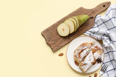 Lezzetli armutlu börek tabağı ve sarı arka planda taze meyve.