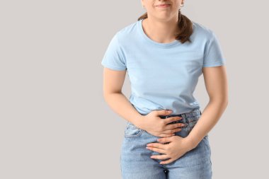 Aybaşı sancılarından muzdarip genç kadın arka planda, yakın plan.