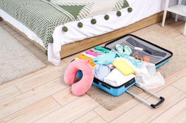 Bavul, boyun yastığı ve yatak odasındaki eşyalar. Seyahat kavramı