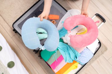 Evde bavul hazırlayan bir kadın. Seyahat konsepti. Üst görünüm