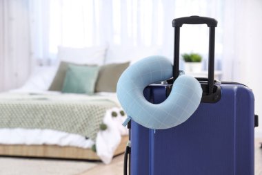 Yatak odasında bavulun üzerindeki boyun yastığı. Seyahat kavramı